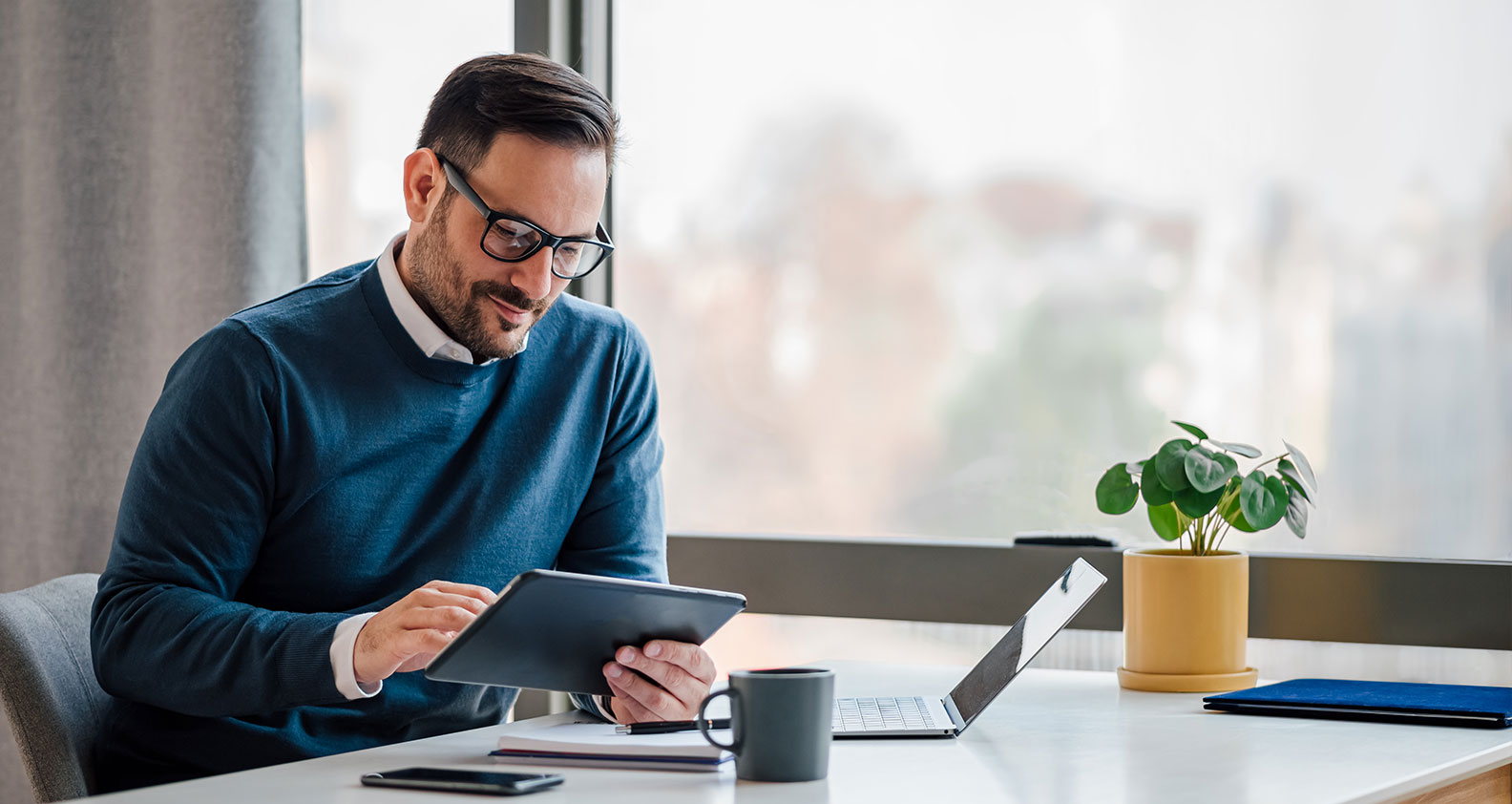 Man sitting in office looking at devices