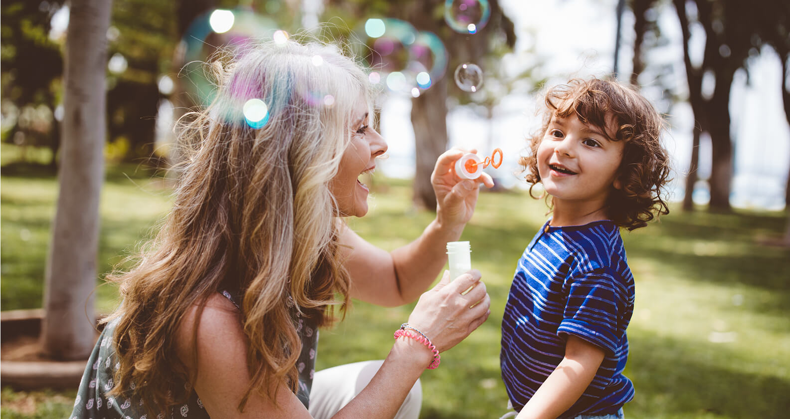 kid blowing bubbles with woman