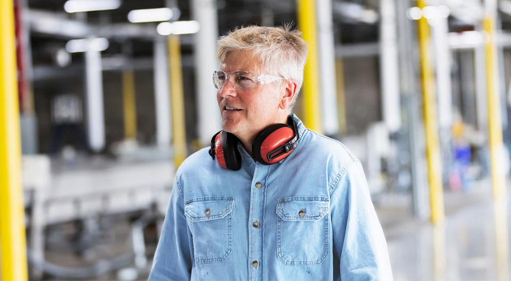 Man with safety ear-muffs in workshop